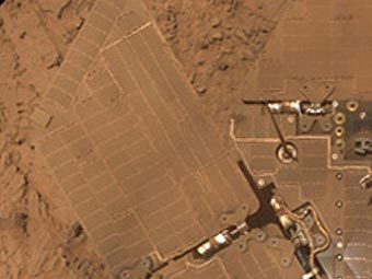 Покрытые пылью солнечные батареи марсохода на фоне окружающего ландшафта. Снимок NASA Покрытые пылью солнечные батареи марсохода на фоне окружающего ландшафта. Снимок NASA